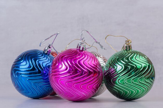 Boules colorées de Noël sur tableau blanc.