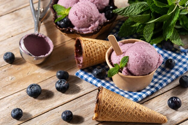 Boules de crème glacée aux bleuets avec gaufre sur table en bois