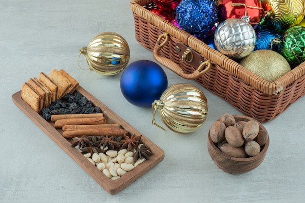 Boules de fête de Noël avec plaque en bois de bâtons de cannelle, anis étoilé sur fond blanc. Photo de haute qualité