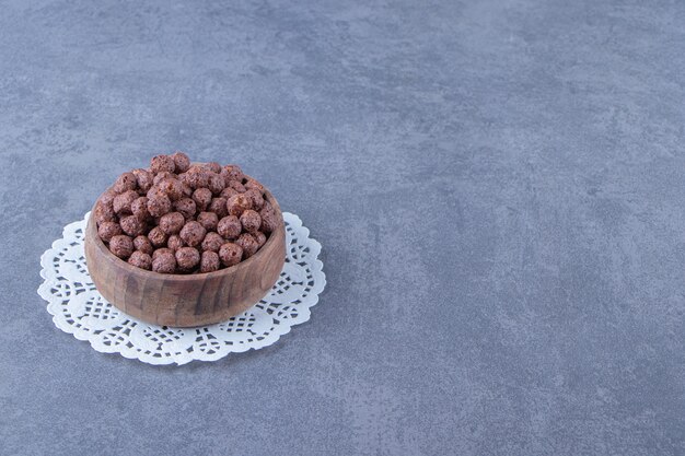 Boules de maïs dans un bol sur un sous-verre, sur fond de marbre. photo de haute qualité