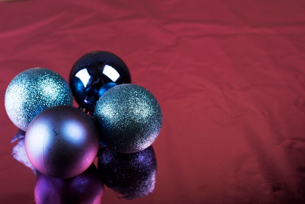 Boules de Noël brillantes sur un tissu bordeaux