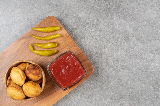 Boulettes frites et poivrons marinés sur planche de bois