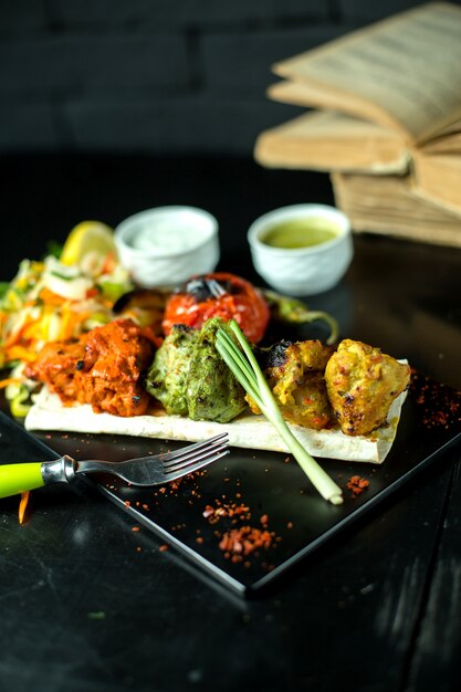 Boulettes de viande multicolores avec tomates et sauces et oignons verts