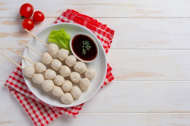 Boulettes de viande de porc sur la surface en bois blanche.