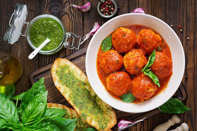 Boulettes de viande à la sauce tomate et toasts au pesto au basilic.