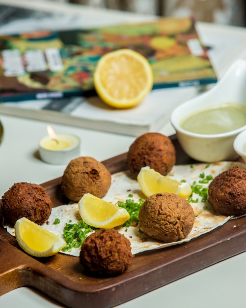 Photo gratuite boulettes de viande servies avec citron et sauce