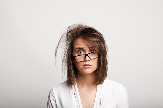 Bouleversé, femme aux cheveux en désordre et au regard en détresse