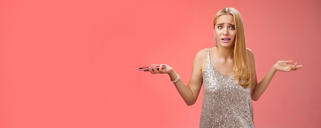 Photo gratuite bouleversé frustré sous-évalué petite amie séduisante blonde haussant les mains sur le côté consternation semble remis en question