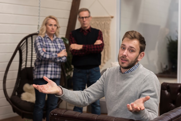 Photo gratuite bouleversé les parents regardant son fils sur le canapé