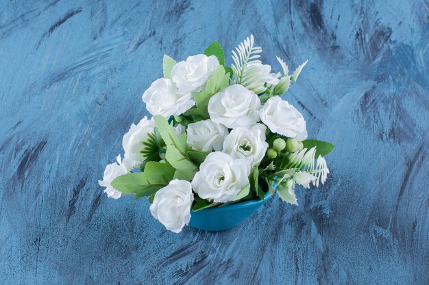 Bouquet avec arrangement de roses blanches naturelles sur bleu.