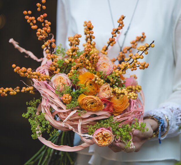 Bouquet d'automne avec des roses jaunes et des baies