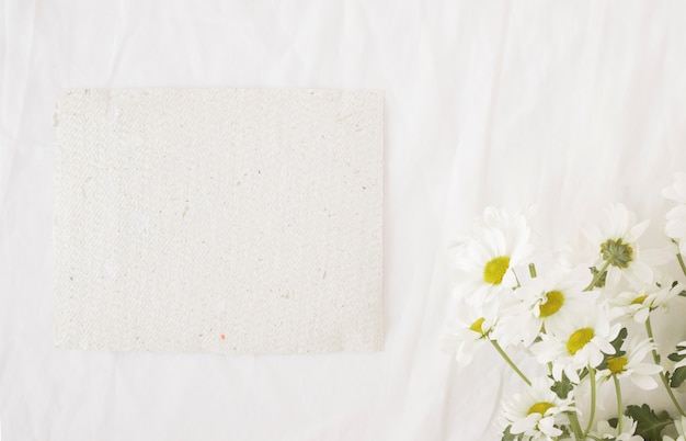 Bouquet de belles fleurs sur des tiges vertes près du papier recyclé