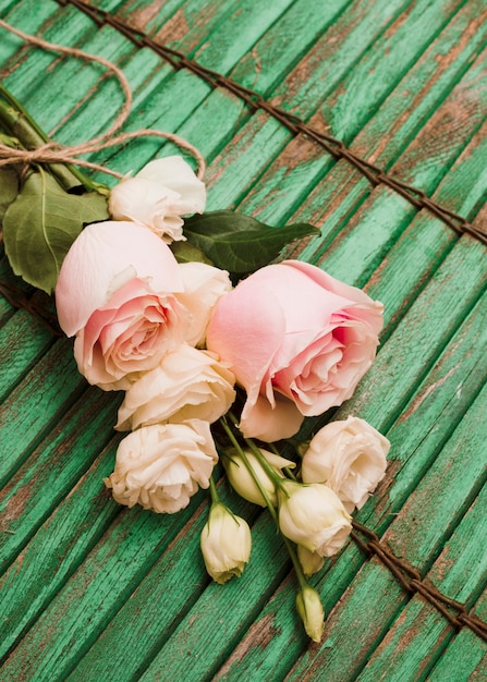 Bouquet de belles roses roses et eustoma sur un vieux fond de volet en bois