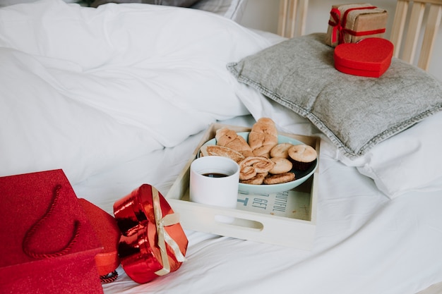 Photo gratuite bouquet de cadeaux et petit déjeuner sur le lit
