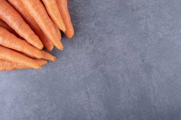 Bouquet de carottes fraîches, sur le fond de marbre.