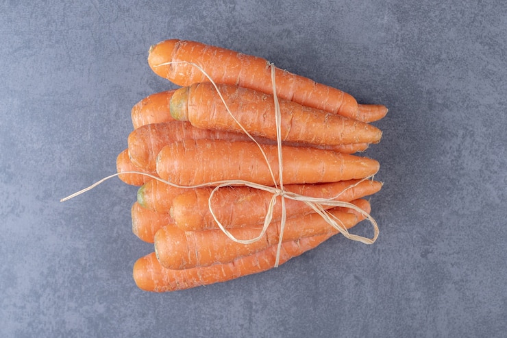Photo gratuit bouquet de carottes fraîches, sur la surface en marbre.