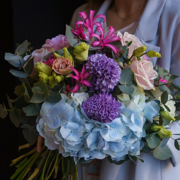 Un bouquet coloré d'oeillets, de roses, de windflowers et de fleurs en soie