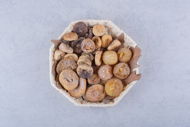 Bouquet de figues séchées sucrées placées dans un panier en osier.