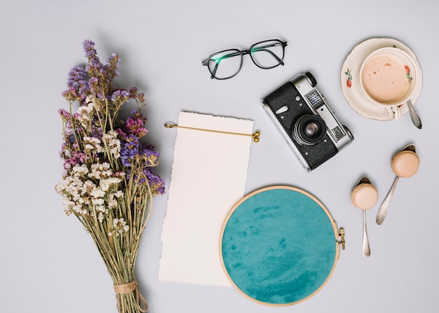 Bouquet de fleurs avec appareil photo et café sur la table lumineuse