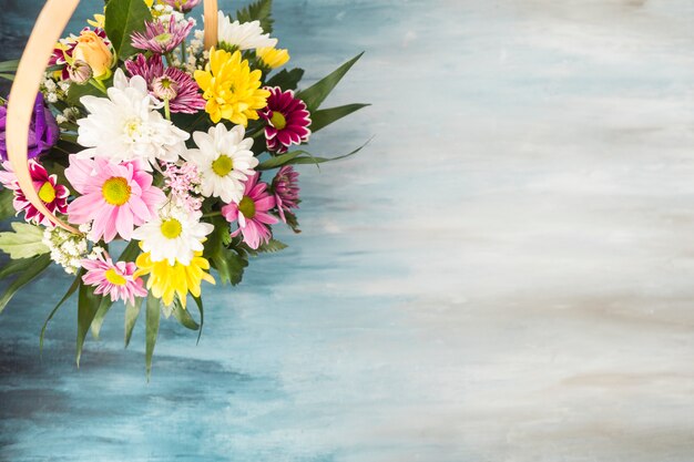 Bouquet de fleurs dans le panier en osier posé sur la table