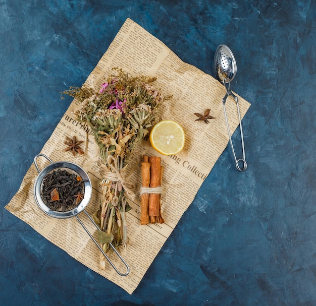 Photo gratuite bouquet de fleurs dans une planche à découper avec de la cannelle, du citron et une passoire à thé