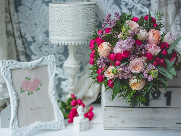 Bouquet de fleurs, lampe de lecture et cadre photo