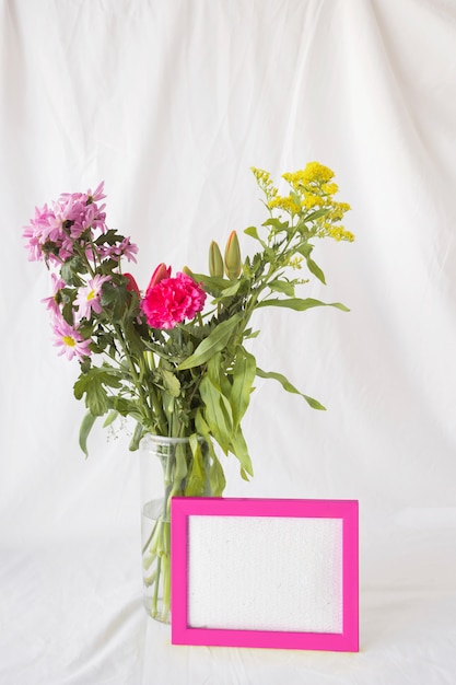 Bouquet de fleurs sur des tiges vertes dans un vase près du cadre