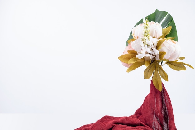 Bouquet de fleurs avec tissu rouge.