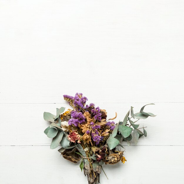 Bouquet d&#39;herbes séchées et de fleurs sur une surface blanche