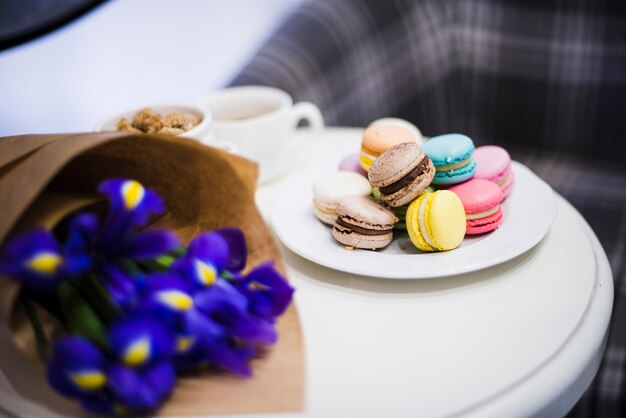 Bouquet d&#39;iris avec des macarons colorés sur une plaque blanche