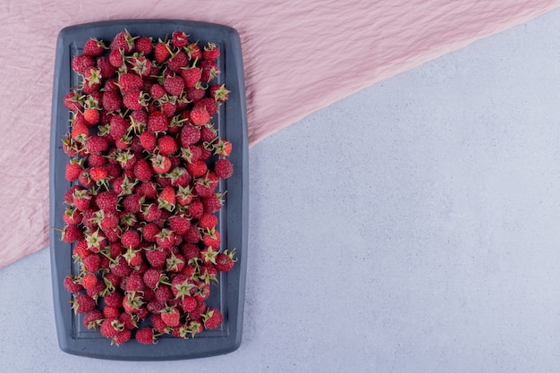 Bouquet juteux de framboises sur une planche marine sur fond de marbre. photo de haute qualité