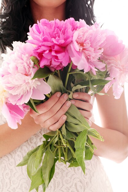 Bouquet de pivoines dans les mains de la femme