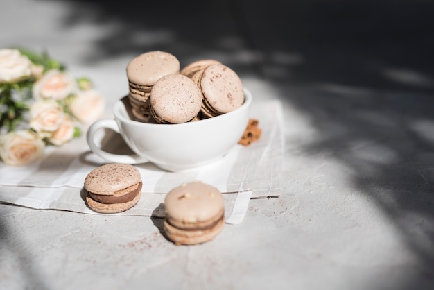 Bouquet de rose avec bol de macarons sur fond de texture en béton