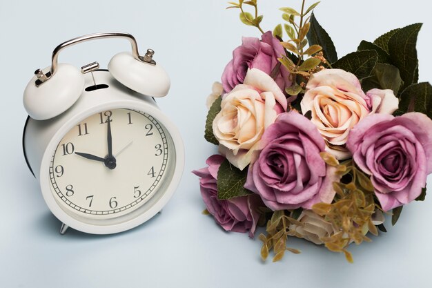 Bouquet de roses à côté de l'horloge