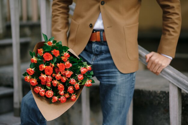 Un bouquet de roses dans des mains masculines.