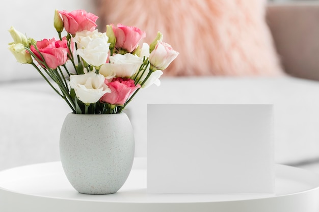 Bouquet de roses dans un vase à côté de carte vide
