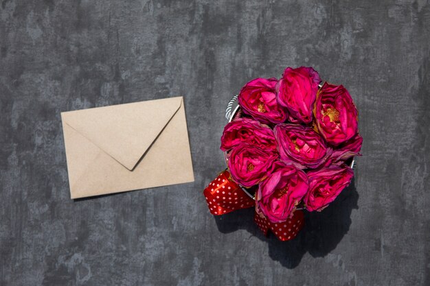 Bouquet de roses avec enveloppe blanche