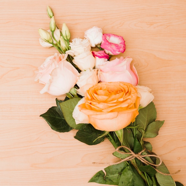 Photo gratuite bouquet de roses sur fond texturé en bois