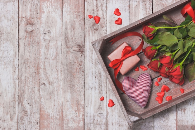 Bouquet de roses sur un plateau avec un coeur et un cadeau