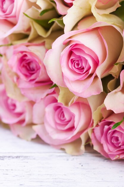 Bouquet de roses roses avec ruban bleu sur un fond en bois millésime
