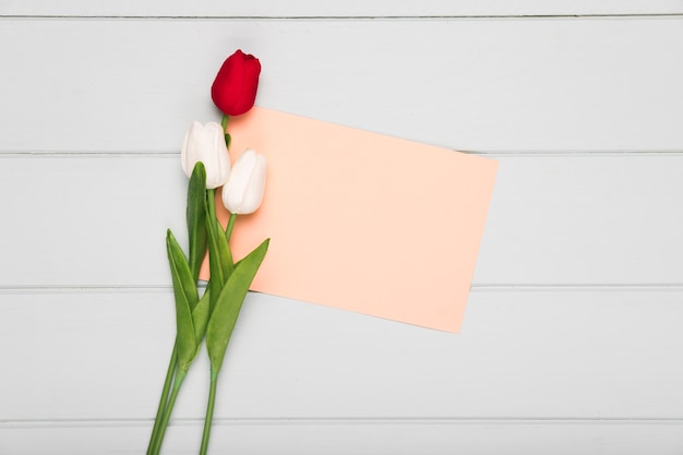 Photo gratuite bouquet de tulipes avec carte de voeux à côté