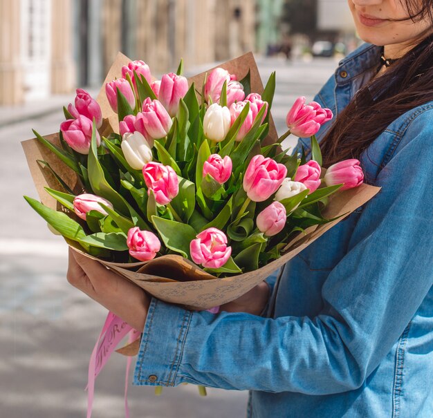 bouquet de tulipes roses dans les mains de la fille