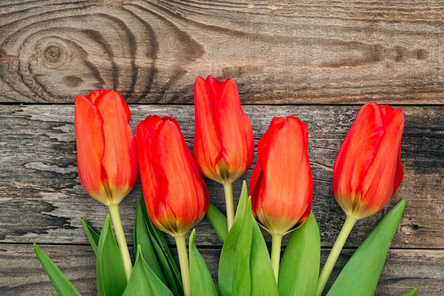 Photo gratuite bouquet de tulipes rouges sur une vue de dessus de fond en bois