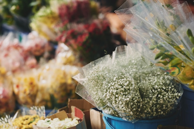 Bouquets de fleurs assorties présentées dans des seaux à l'extérieur du magasin de fleurs