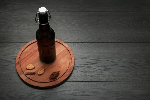 Bouteille de bière sur une planche à découper avec espace de copie
