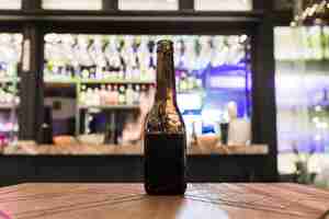 Photo gratuite bouteille de bière sans capuchon sur la table en bois dans le bar