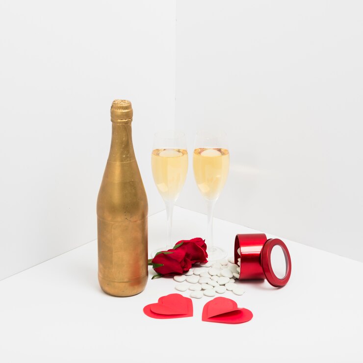 Photo gratuit bouteille de champagne avec des coeurs de papier