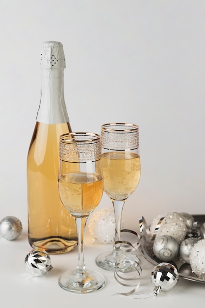 Photo gratuite bouteille de champagne avec des lunettes sur la table