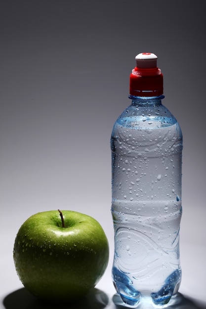 Bouteille d'eau froide fraîche et pomme verte