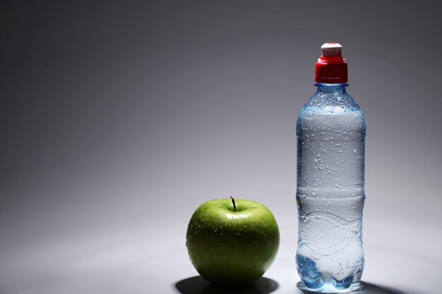 Bouteille d'eau froide fraîche et pomme verte